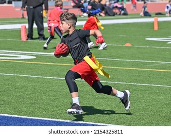 Young athletic boy catching, running and throwing the ball in a football game - Powered by Shutterstock