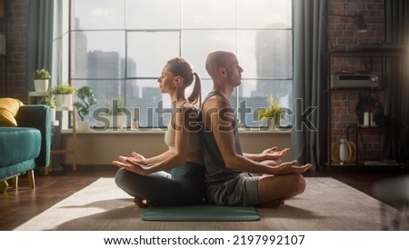 Young Athletic Couple Exercising, Practising Meditation in the Morning in Her Bright Sunny Home Living Room. Healthy Lifestyle, Fitness, Wellbeing and Mindfulness Practice Concept.