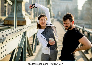 Young athletic couple is having a rest after jogging in the city