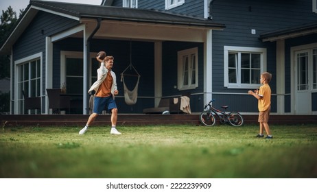 Young Athletic Father Playing Ball with His Young Son. Dad Teaching the Boy to Play American Football. Kid Learning to Throw the Rugby Ball Correctly. Family Members Playing Outside Their Home. - Powered by Shutterstock