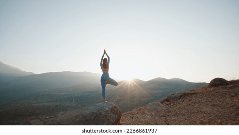 Young athletic girl meditating, doing various yoga poses, training in mountains during sunrise - active lifestyle, zen concept - Powered by Shutterstock