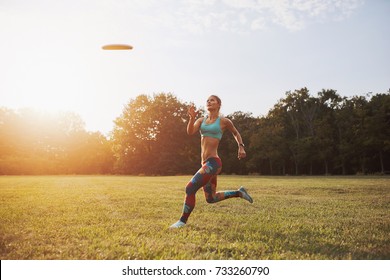 Young athletic girl playing with flying disc in the park. Professional player. Sport concept - Powered by Shutterstock