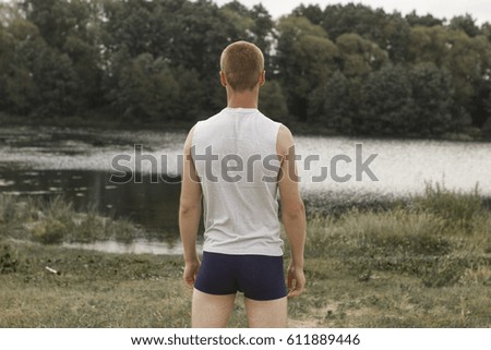 sports guy in his underwear looking at the river