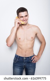 Young Athletic Guy Eating A Banana