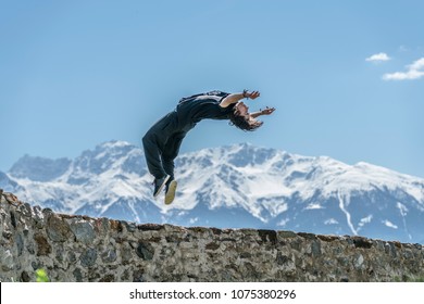 Young Athletic Guy Performing A Parkour Backflip In The Mountains