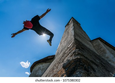 Young Athletic Guy Performing A Parkour Backflip With The Sun In The Background