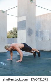 Young Athletic Man Doing Burpee On Parkour Area. Training Alone Outdoors.