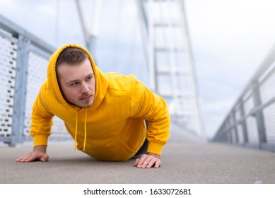 Young athletic man doing push ups outdoors.