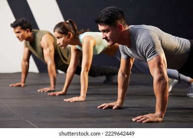 young athletic man doing push up with on the gym floor
