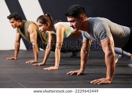young athletic man doing push up with on the gym floor