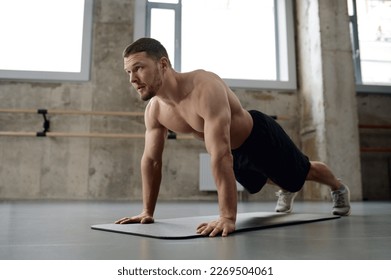 Young athletic man doing push-ups physical workout in gym - Shutterstock ID 2269504061
