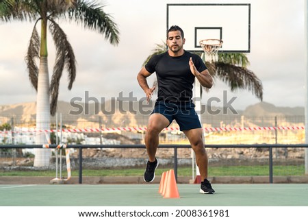 Young athletic man doing running exercises outdoor - Sporty people lifestyle concept