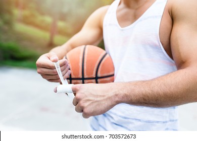 Young Athletic Man Fixing Injury On Basketball Court