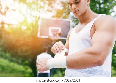 Young Athletic Man Fixing Injury On Basketball Court