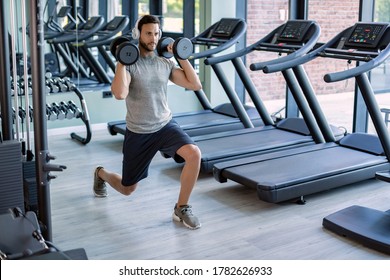 Young Athletic Man Having Weight Training In Lunge Position In A Gym. 