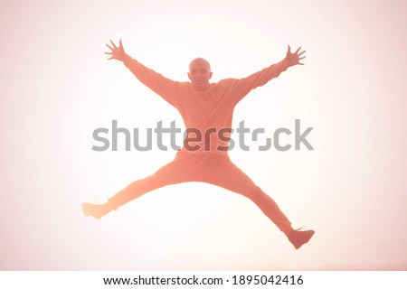 Young athletic man jumping high outdoors. Flying, freedom, happiness