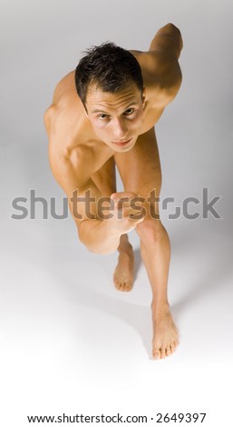 Young athletic man preparing to run. White background in studio.