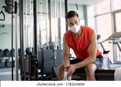 Young athletic man wearing protective face mask while having sports training in a gym during coronavirus epidemic.  - Powered by Shutterstock