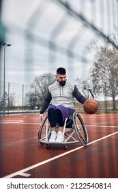 Young Athletic Man In Wheelchair Exercising Basketball On Outdoor Sports Field. 
