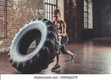 Young Athletic Woman With A Crossfit Wheel Indoors