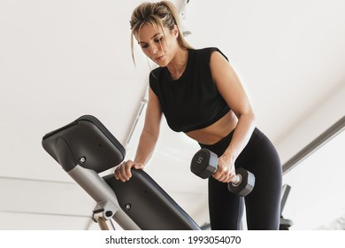 Young Athletic Woman Doing One Arm Dumbbell Row Exercise In The Gym