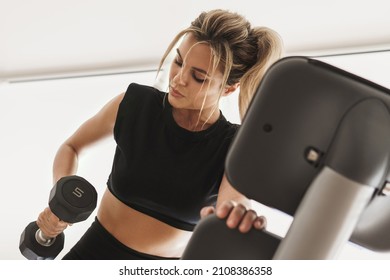 Young Athletic Woman Doing One Arm Dumbbell Row Exercise In The Gym