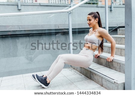 Young, athletic woman excercising her upper body during a bootcamp training.