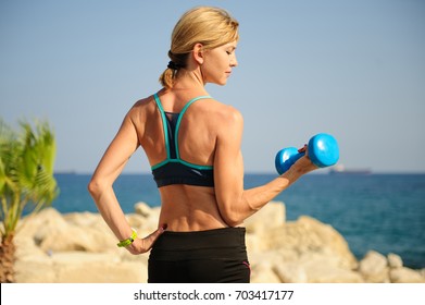 Young Athletic Woman Exercising Outdoors: Bicep Curl For Upper Body Strength