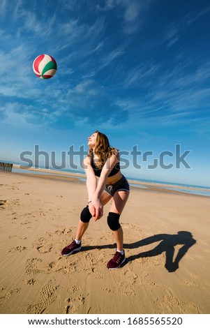 young athletic woman playing beach volley