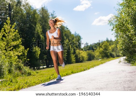 young athletic woman running on the road, exercise outdoors