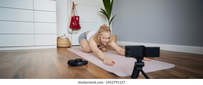 Young athletic woman trainer practicing Hatha Yoga, instructor personal training Vasisthasana, balancing pose, workout at home. Concept of healthy lifestyle and wellbeing. - Powered by Shutterstock