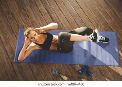 Young Athletic Woman Training Hard With Gym Exercise At Home, Lying At Mat. Upper View