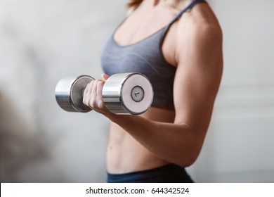 Young Athletic Woman Training Hard With Dumbells At Home. Fitness And Healthy Lifestyle Concept With Beautiful Sportive Caucasian Model