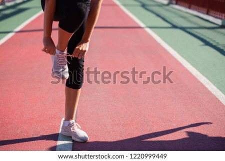 Similar – Young woman stretching legs before training outdoors