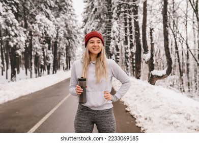 Young athletic woman warming up before her winter workout during sunny and snowy day - Powered by Shutterstock