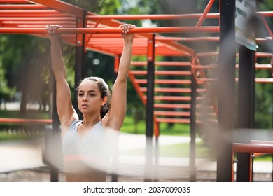 Young Athletic Woman Working Out On Pull Up Bar In Outdoor Gym