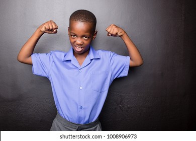 Young Atractive Black Boy Wearing School Unifor Looing Strong And Configent Going To School For The First Time With His Arms In A Muscle Flexing Gesture..