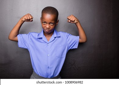 Young Atractive Black Boy Wearing School Unifor Looing Sad And Worried Going To School For The First Time With His Arms In A Muscle Flexing Gesture..