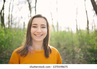 Young And Attracive Woman Standing And Laughing In The Woods. Lifestyle,health And Enviromental Protection Concept. Vintage Analog Film Look.