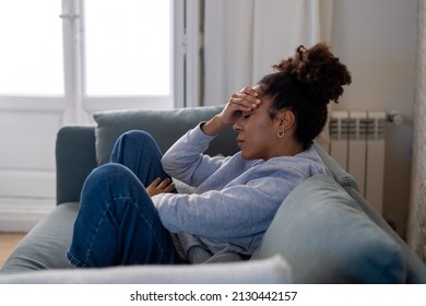 Young attractive african american woman lying at home living room couch feeling sad tired and worried suffering depression, distress and anxiety in mental health, problems and broken heart concept. - Shutterstock ID 2130442157