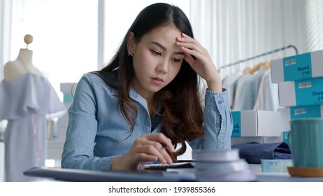 Young Attractive Asia Female Business Owner Thoughtful Serious Doubtful Feel Stress Worry With Financial Problem In SME Crisis Small Business Challenges Impact From Covid Coronavirus At Home Office.