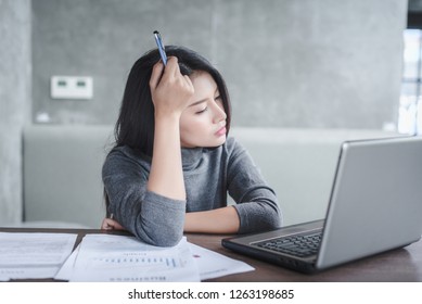 Young Attractive Asian Business Woman Sleeping, Drowsing Or Taking A Nap At Her Desk, Tired Business Woman Accountant With Bills And Paper Folders In Office, Tired Young Business Woman With Laptop.