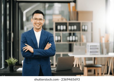 Young attractive Asian Businessman smiling thinking planning writing in notebook, tablet and laptop  looking at camera at office 
 - Powered by Shutterstock