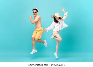 Young attractive Asian couple jumping together isolated on light blue studio background - Powered by Shutterstock