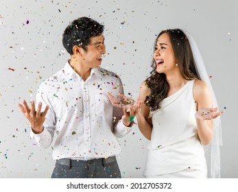 Young Attractive Asian Couple, Man Wearing White Shirt, Woman Wearing White Dress With Wedding Veil Standing Together Celebrating. Concept For Pre Wedding Photography.