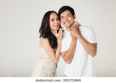 Young Attractive Asian Couple, Man Wearing White T Shirt And Beige Pants, Woman Wearing Beige Dress. Teasing Each Other. Concept For Pre Wedding Photography.