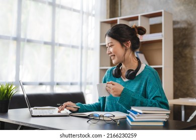 Young attractive asian female employee with headphone listen to digital online course development program. - Shutterstock ID 2166230259