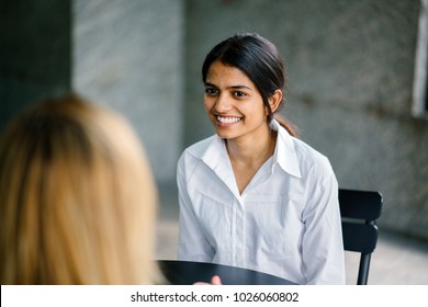 A Young And Attractive Asian Indian Woman Is Interviewing For A Job. She Is Smiling And Is Relaxed And Calm -- The Interview Is Going Well. 