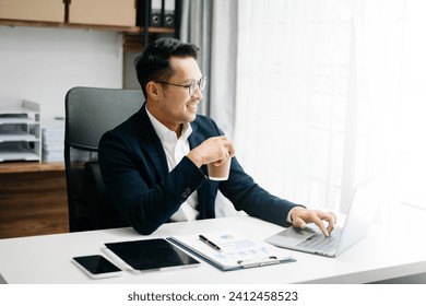 Young attractive Asian male office worker business suits smiling at camera in office  - Powered by Shutterstock