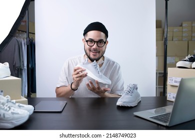 Young Attractive Asian Man Blogger Or Vlogger Looking At Camera Reviewing Product. Modern Businessman Using Social Media For Marketing. Business Online Influencer On Social Media Concept.